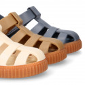 SNEAKER style kids jelly shoes with hook and loop strap in solid colors and caramel soles.