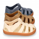 SNEAKER style kids jelly shoes with hook and loop strap in solid colors and caramel soles.