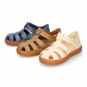 SNEAKER style kids jelly shoes with hook and loop strap in solid colors and caramel soles.