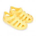 SNEAKER style kids jelly shoes with hook and loop strap in solid colors and matching soles.