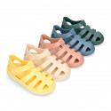 SNEAKER style kids jelly shoes with hook and loop strap in solid colors and matching soles.