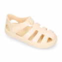 SNEAKER style kids jelly shoes with hook and loop strap in solid colors and matching soles.