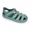 SNEAKER style kids jelly shoes with hook and loop strap in solid colors and matching soles.