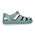 SNEAKER style kids jelly shoes with hook and loop strap in solid colors and matching soles.