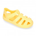 SNEAKER style kids jelly shoes with hook and loop strap in solid colors and matching soles.