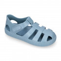 SNEAKER style kids jelly shoes with hook and loop strap in solid colors and matching soles.