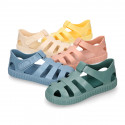 SNEAKER style kids jelly shoes with hook and loop strap in solid colors and matching soles.