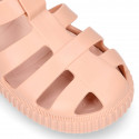 SNEAKER style kids jelly shoes with hook and loop strap in solid colors and matching soles.