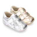 Baby sneaker with hook-and-loop closure in laminated leather.