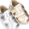 Baby sneaker with hook-and-loop closure in laminated leather.