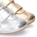 Baby sneaker with hook-and-loop closure in laminated leather.