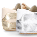 Baby sneaker with hook-and-loop closure in laminated leather.