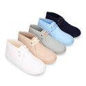 Cotton canvas Wallabee style bootie shoes with ties closure.