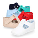 Cotton canvas T-strap shoes with hook and loop strap for babies.