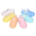 Tennis style kids jelly shoes with hook and loop strap and soles in colors.