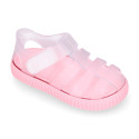 Tennis style kids jelly shoes with hook and loop strap and soles in colors.