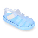 Tennis style kids jelly shoes with hook and loop strap and soles in colors.