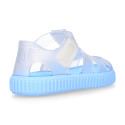 Tennis style kids jelly shoes with hook and loop strap and soles in colors.