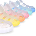 Tennis style kids jelly shoes with hook and loop strap and soles in colors.