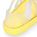 Tennis style kids jelly shoes with hook and loop strap and soles in colors.