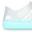 Tennis style kids jelly shoes with hook and loop strap and soles in colors.