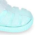 Tennis style kids jelly shoes with hook and loop strap and soles in colors.