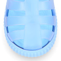 Tennis style kids jelly shoes with hook and loop strap and soles in colors.