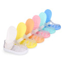 Tennis style kids jelly shoes with hook and loop strap and soles in colors.