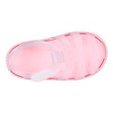 Tennis style kids jelly shoes with hook and loop strap and soles in colors.