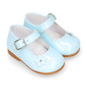 Classic patent leather little Mary Jane shoes with flower detail.