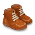 Suede leather ankle boots with fringed and central stitches design.