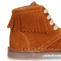 Suede leather ankle boots with fringed and central stitches design.