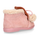 Booties with shoelaces closure with pompons and fake hair neck in suede leather for kids.