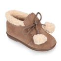 Booties with shoelaces closure with pompons and fake hair neck in suede leather for kids.