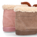 Booties with shoelaces closure with pompons and fake hair neck in suede leather for kids.