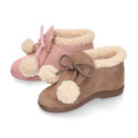 Booties with shoelaces closure with pompons and fake hair neck in suede leather for kids.