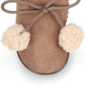 Booties with shoelaces closure with pompons and fake hair neck in suede leather for kids.