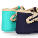 Classic cotton canvas T-Strap shoes for babies with hook and loop strap.