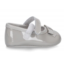 Classic little ballet flat shoes for babies with hook and loop strap and ribbon in patent leather.