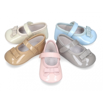 Classic little ballet flat shoes for babies with hook and loop strap and ribbon in patent leather.