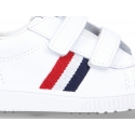 Washable leather tennis shoes laceless and with flag design.