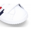 Washable leather tennis shoes laceless and with flag design.